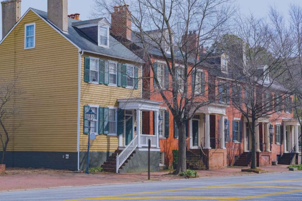 Historic Norfolk home before a home maintenance inspection, showing weathered wood siding and brick chimney