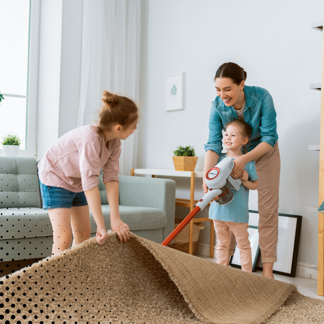 A mom and her children having fun as they clean the living room together