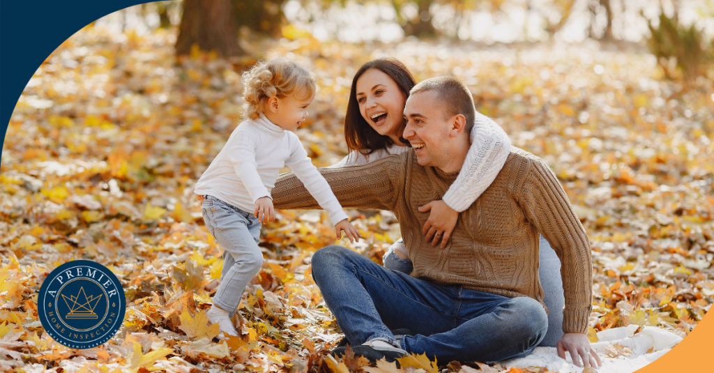 Happy family of three playing in autumn leaves, representing a fun and joyful moment outdoors
