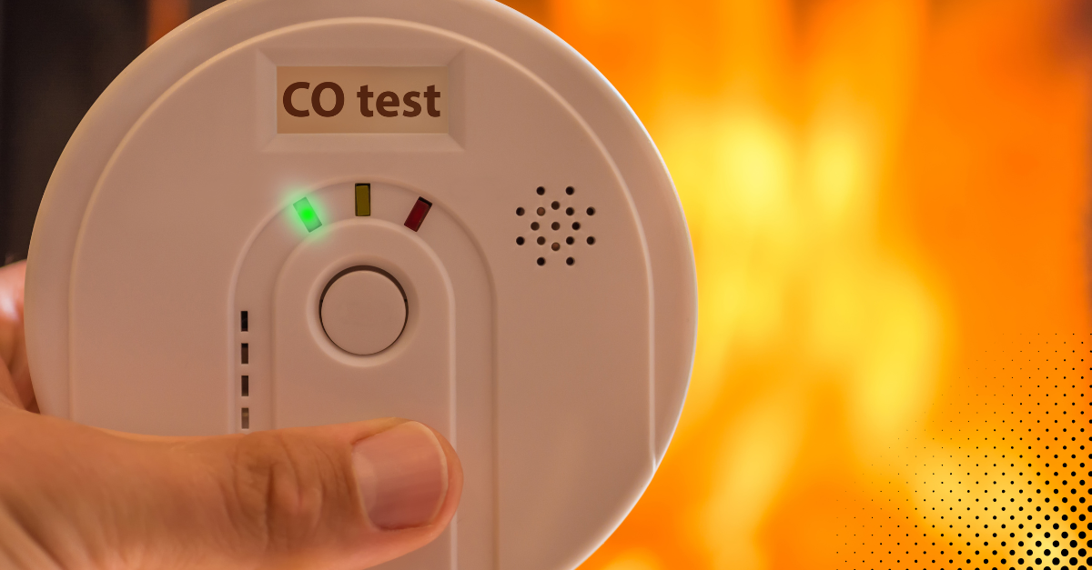 Hand holding a carbon monoxide detector with a CO test indicator light