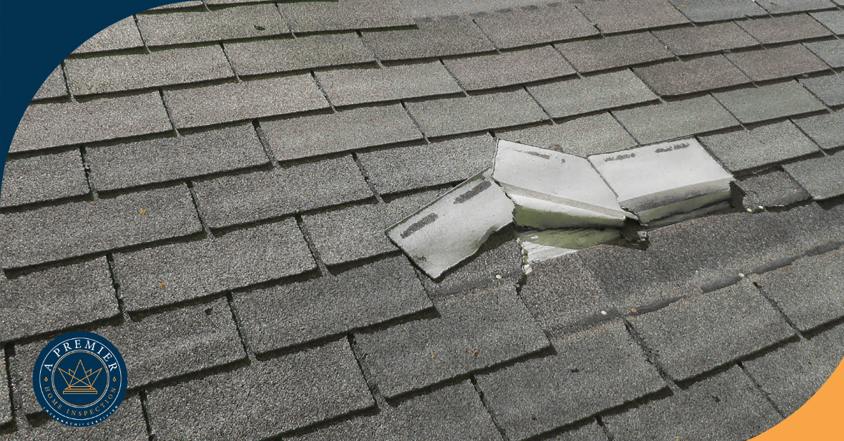 Severe roof damage with broken shingles exposing underlayment, needing repair