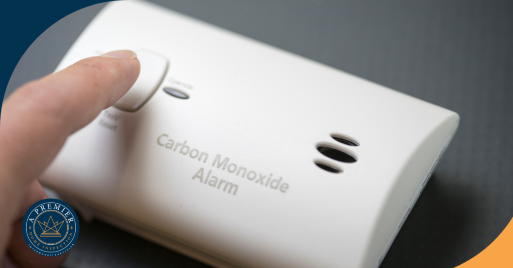 A person pressing a button on a carbon monoxide alarm