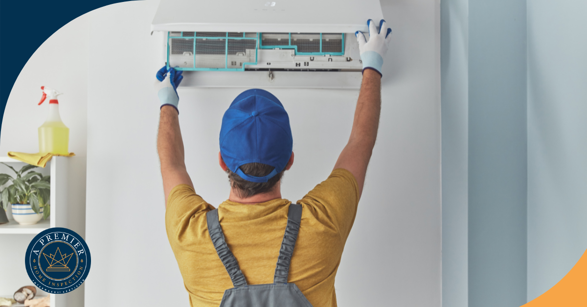 Technician inspecting and cleaning indoor HVAC unit