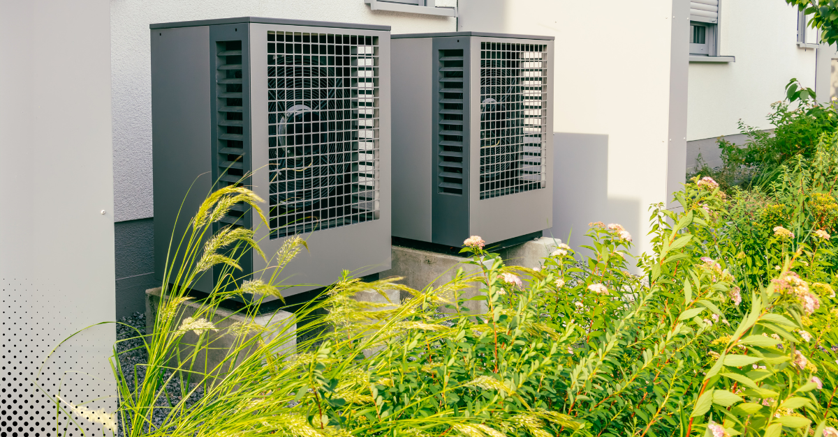 Outdoor HVAC units beside a house with surrounding greenery